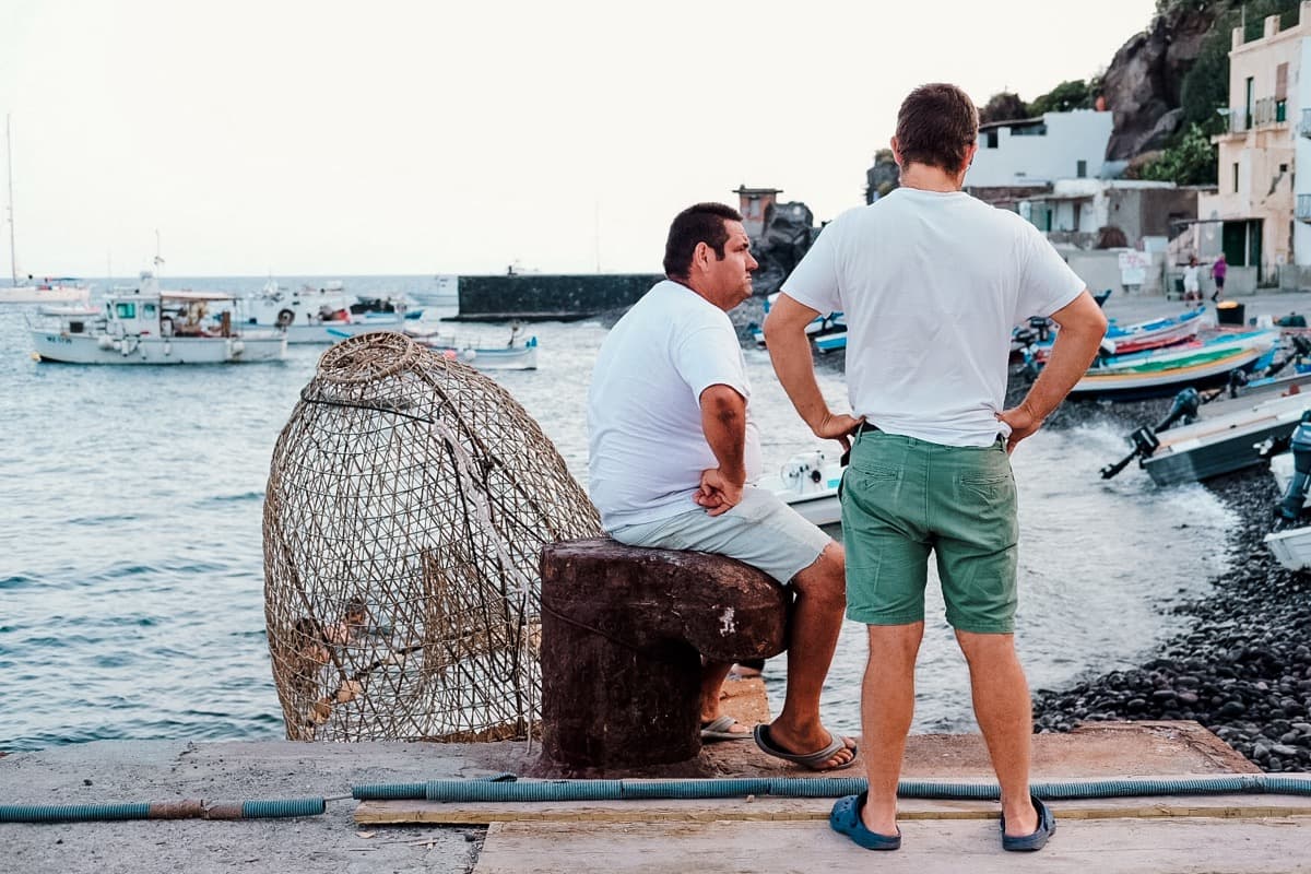 Zwei Männer am Steg von Alicudi, Reuse im Vordergrund