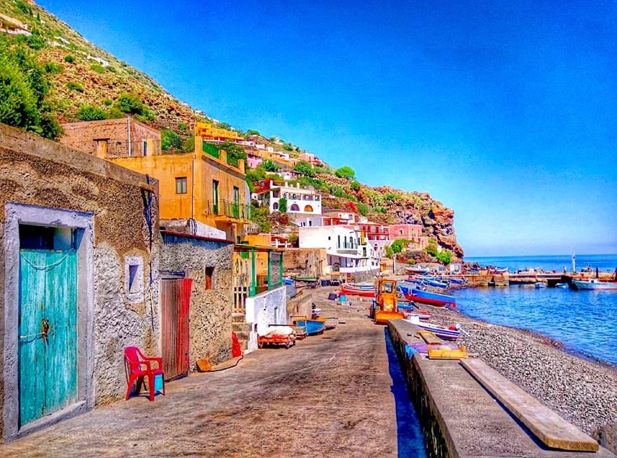 Bunte Hafengasse von Alicudi mit türkisfarbener Tür