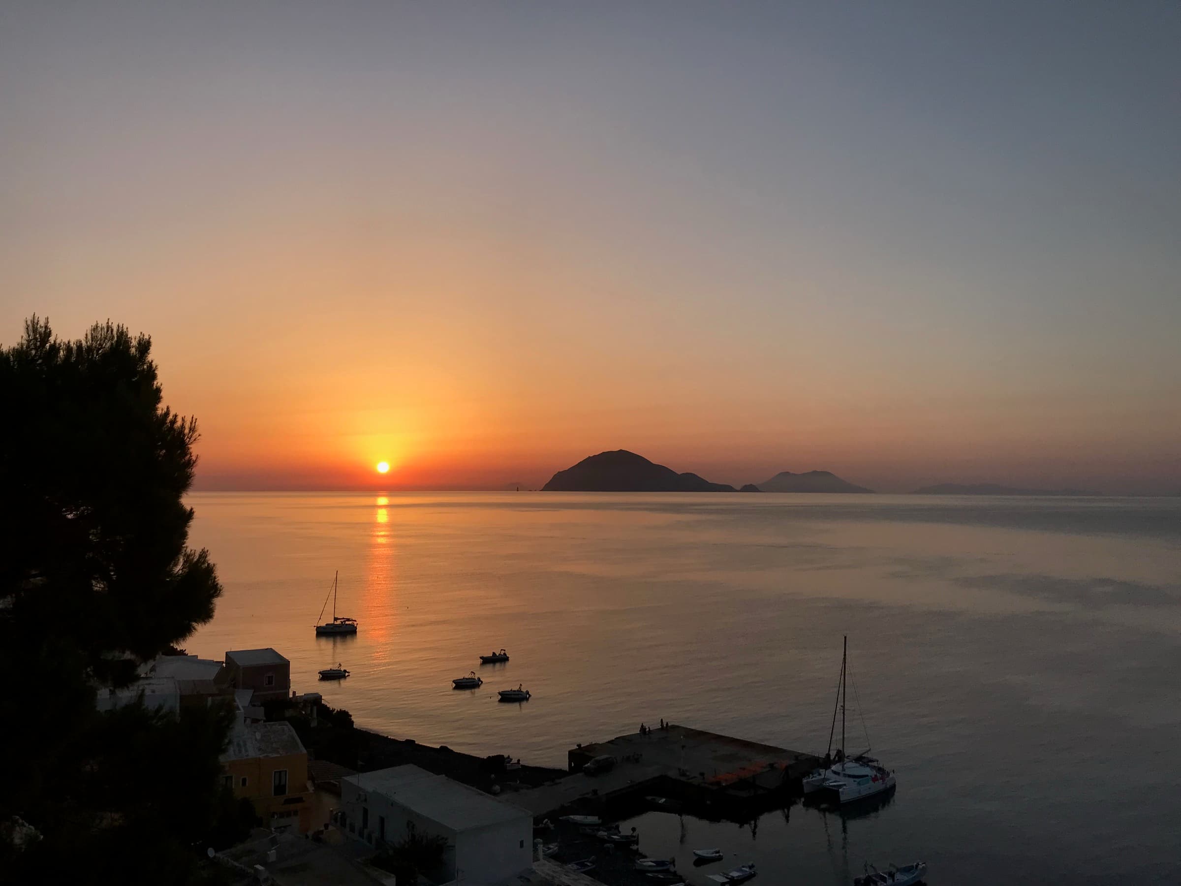 Sonnenuntergang über dem Hafen von Alicudi, Filicudi dahinter