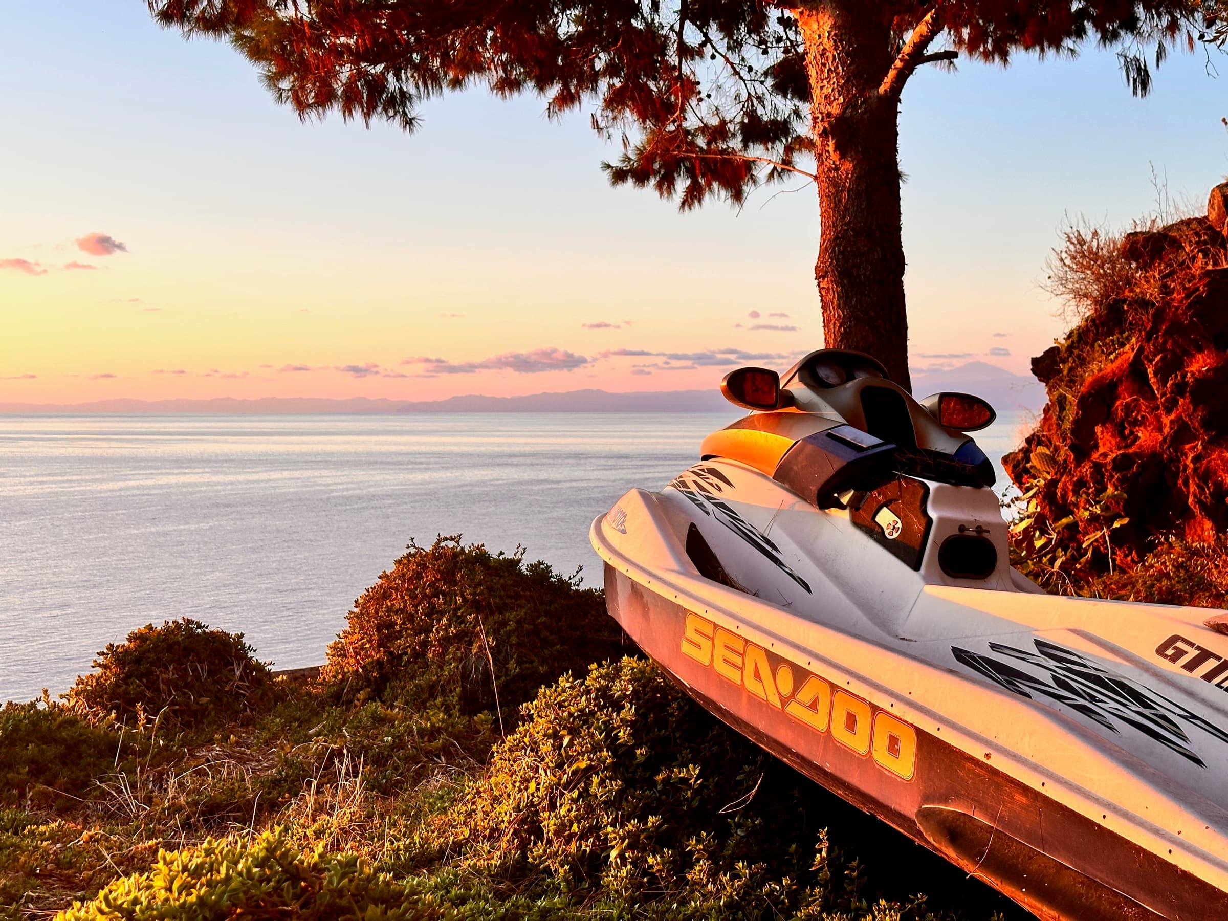 Jet-Ski unter einer großen Pinie bei Sonnenuntergang auf Alicudi